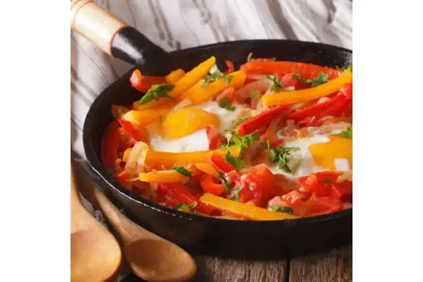 Poêlée colorée de poivrons et œufs, un plat savoureux qui rappelle la recette piperade grand-mère.