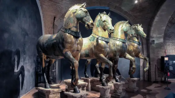 Les célèbres chevaux de Saint-Marc, statues de bronze patiné, se dressent fièrement dans un musée, leurs corps musclés capturant l'essence de la puissance antique.